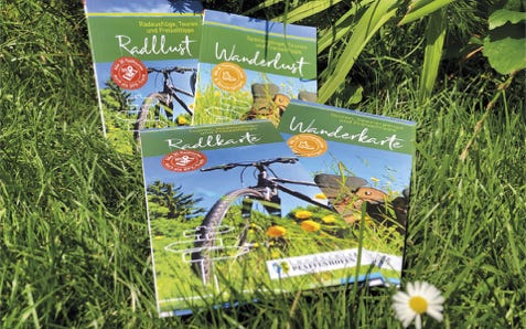 Arbeitsbeispiel für Corporate Design: Tourismus-Broschüren und Freizeitkarten des Landkreises Pfaffenhofen im neuen Erscheinungsbild liegen im Gras